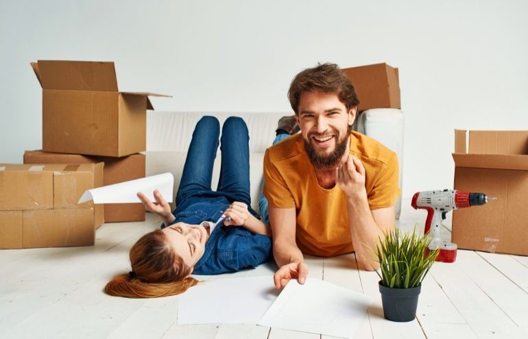Young Couple surrounded moving boxes on floor