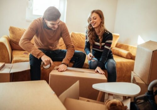 Couple packing up home sitting on couch