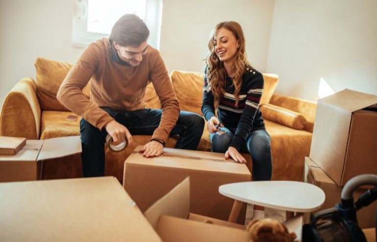 Couple packing up home sitting on couch