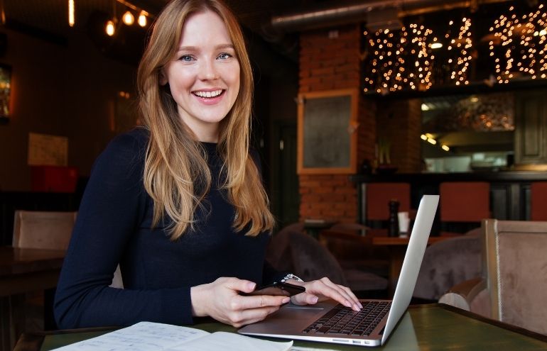 Young Professional Woman holding phone with laptop